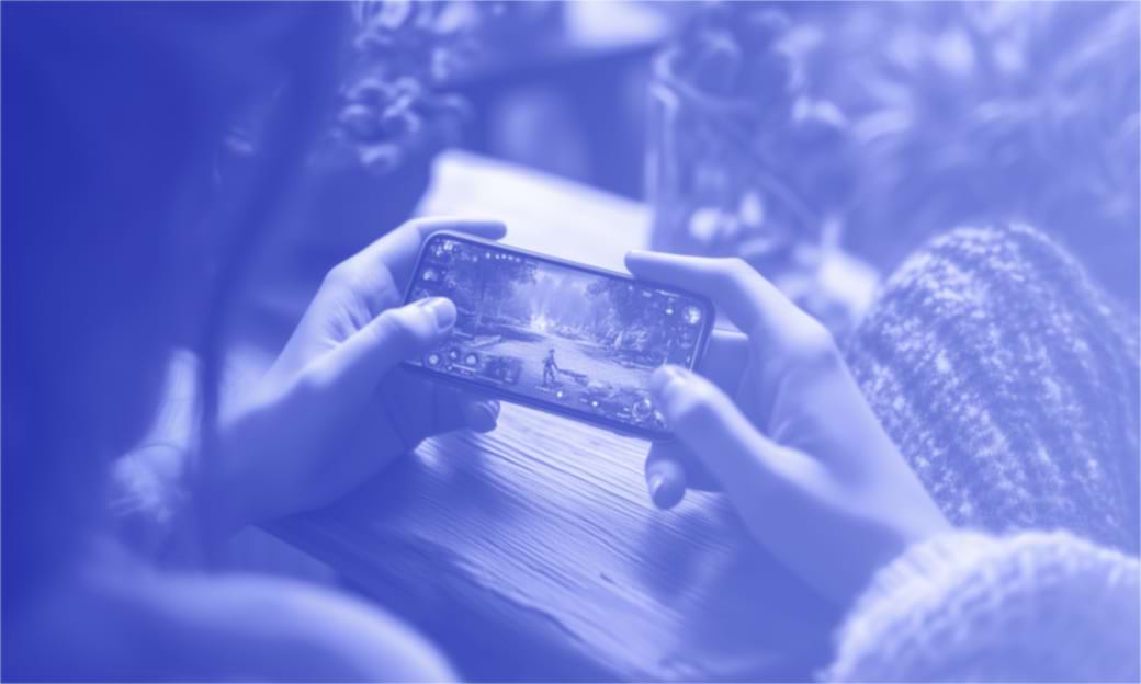 Hands holding smartphone with a video game on