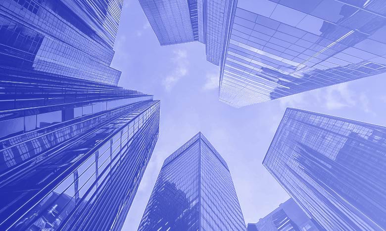 Upward view of modern glass skyscrapers against sky