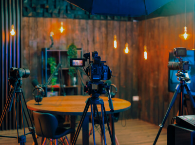 Three cameras on tripods recording a podcast