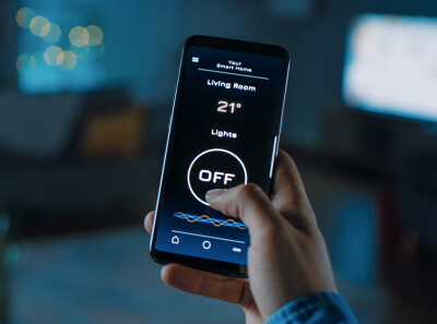 A person controlling living room lights using a phone