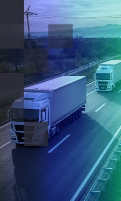 White trucks carrying cargo on a highway