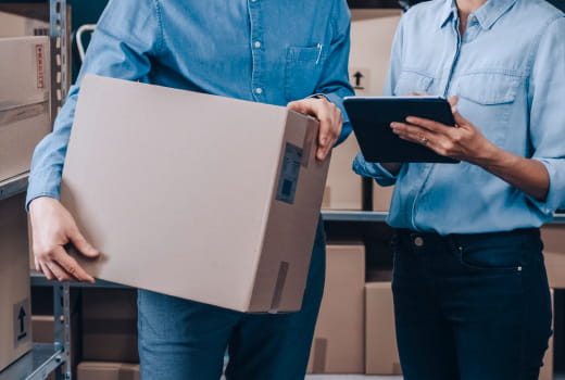 People in a warehouse setting a delivery with a tablet