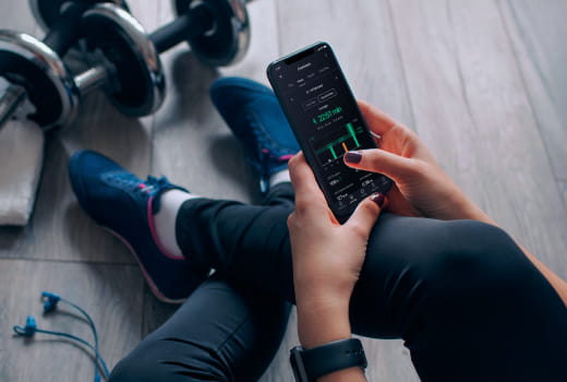 A person in a gym monitoring her activity stats after a workout