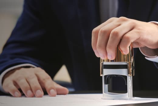 A person wearing a men's suit signs documents