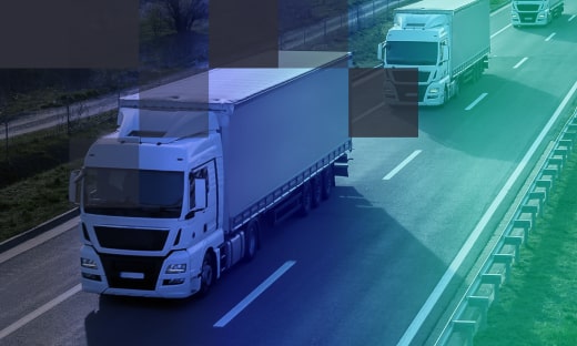White trucks carrying cargo on a highway