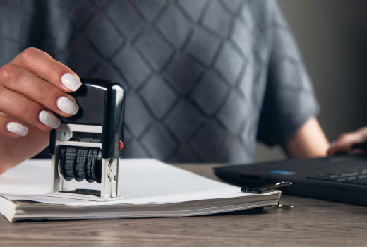 A person stamping a document