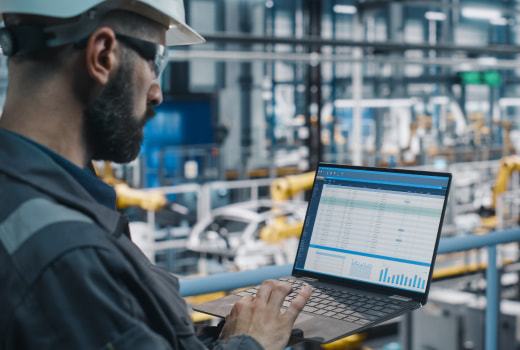 An industrial worker managing plant work process on a laptop
