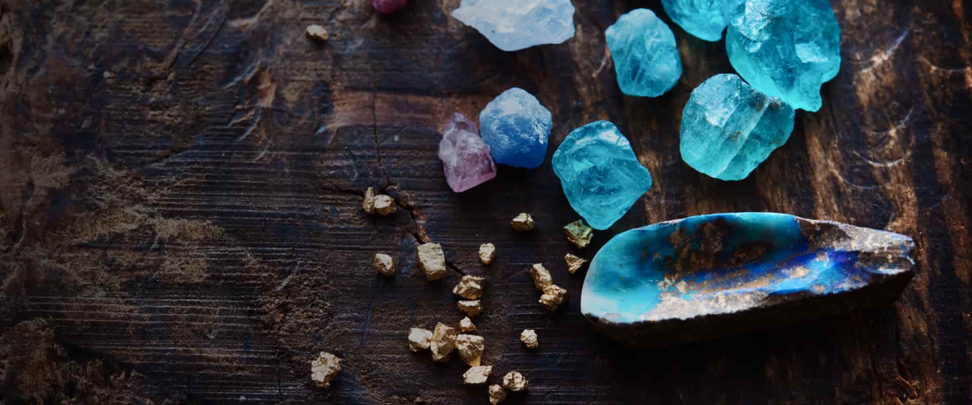 Gemstones and precious metals on a wooden desk