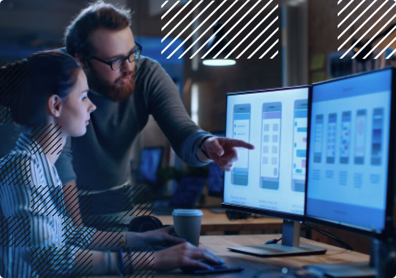 Two people in front of monitors working on IoT application development
