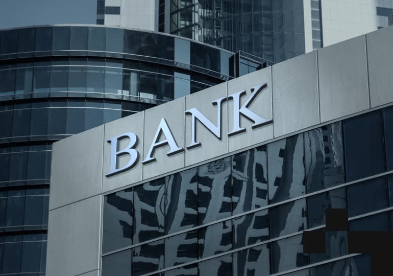 A bank sign on a glass building