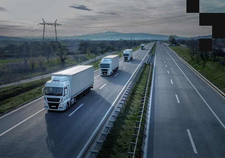 Several trucks following each other on a highway
