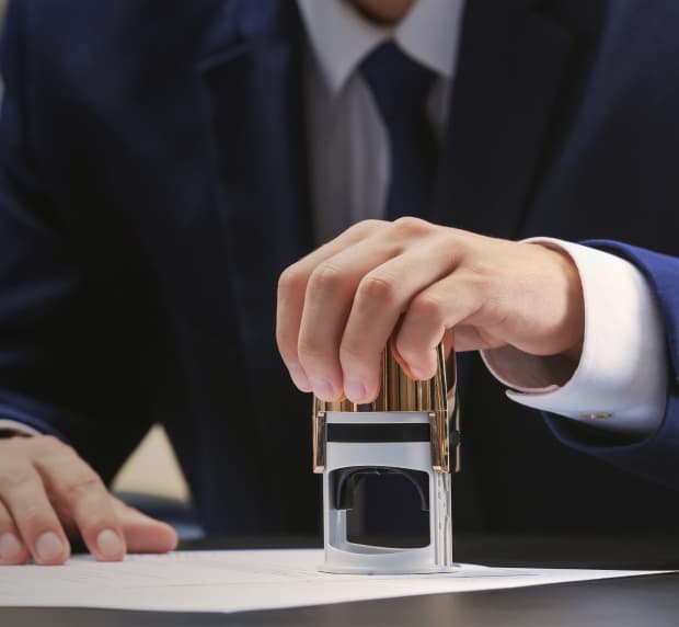 A person wearing signs a document
