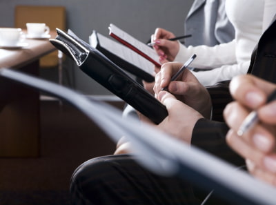 Real estate insurers make notes in notebooks