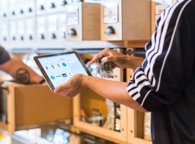 A person picks grocery goods from the list on a tablet