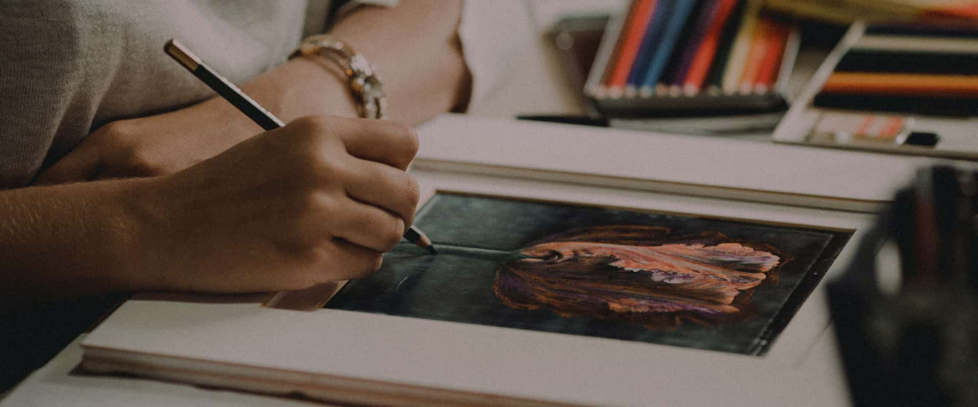 A person drawing a picture of a flower with a green pencil