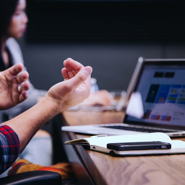 A person wearing a shirt sits at the table and expresses his thoughts