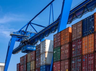 The crane moves colorful containers on docks