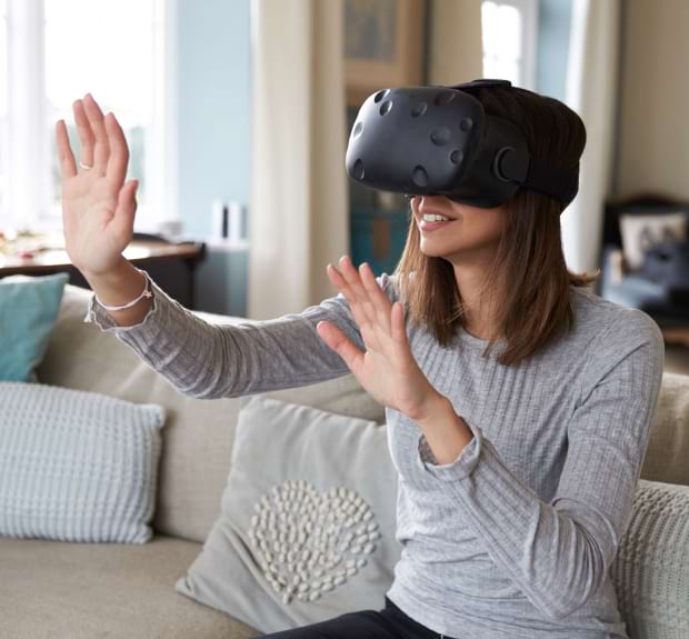 A woman wearing a virtual reality headset, immersed in a digital experience.
