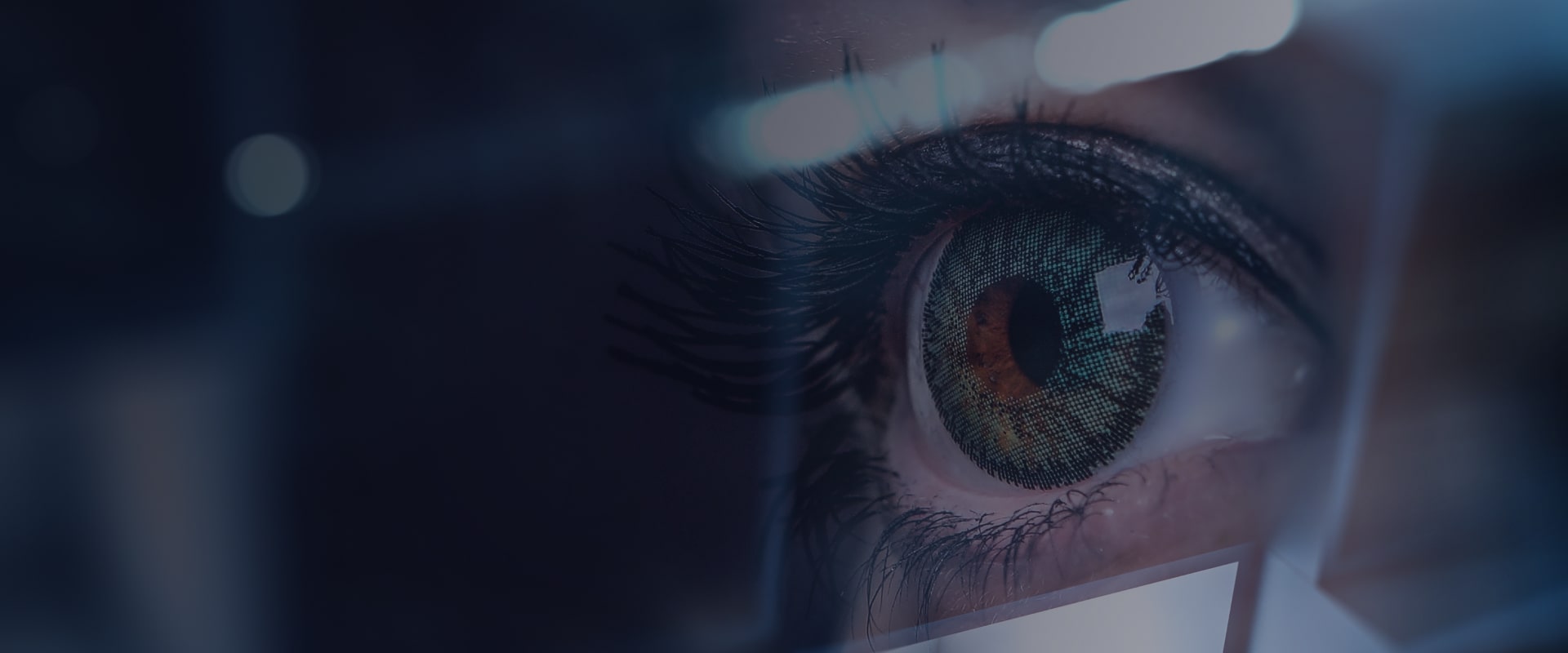 A light-colored human eye against the monitor