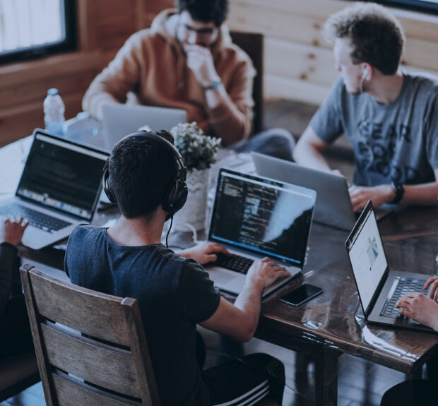 A web development team working on laptops in a coworking space